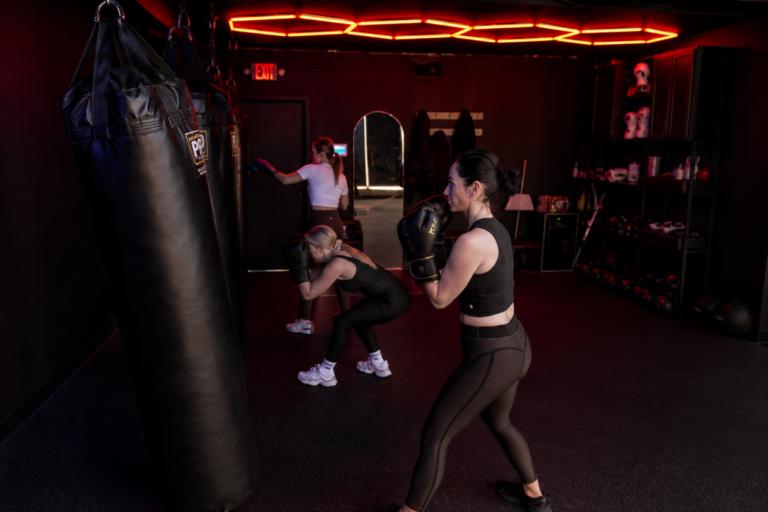 Members working heavy bags in the OG Boxing & Fitness studio